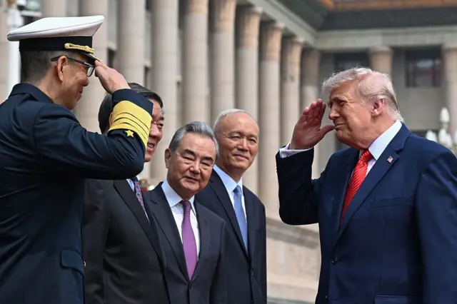 5月14日,美国总统特朗普(右)在北京人民大会堂举行的欢迎仪式上,向中国国防部长董军(左)行礼。