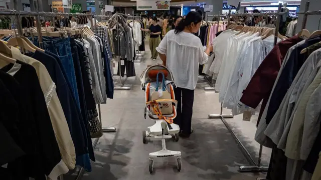 几名女性在女装服饰区过道选购衣服